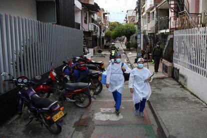 Dos trabajadores de la salud caminan con la vacuna del laboratorio chino Sinovac, en un barrio de Cali, Colombia, el 18 de marzo pasado.