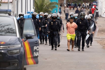 Policías antidisturbios trasladan a un detenido del campamento humanitario de Las Raíces tras los altercados ocurridos en el campamento de La Laguna (Tenerife).