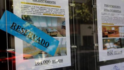 Anuncios de venta de pisos en el escaparate de una inmobiliaria de Madrid.