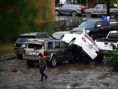 Una mujer camina frente a autos dañados por las inundaciones en San Diego, Estados Unidos, el 22 de enero 2024.