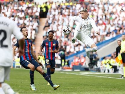 Valverde controla el balón ante Busquets durante el clásico entre el Real Madrid y el Barcelona este domingo en el Santiago Bernabéu.