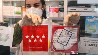 Una farmacéutica muestra las mascarillas KN95 que se reparten gratis en las farmacias de Madrid, el pasado lunes.