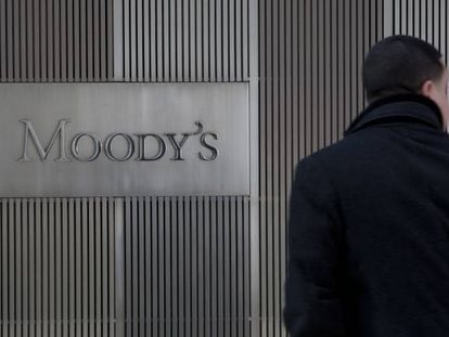 Un hombre ante un cartel de Moddy's en las oficinas de la empresa en Nueva York