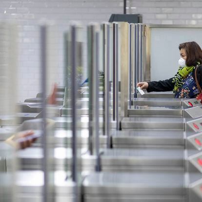 Algunos ciudadanos vuelven al trabajo en transporte público y pasan por la estación de metro Passeig de Gracia en Barcelona.