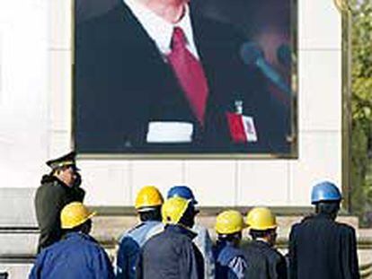 Un grupo de trabajadores ante un retrato de Jiang Zemin, ayer en Pekín.