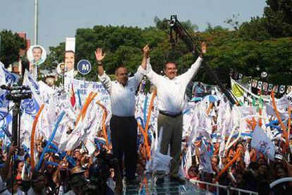 El candidato a la presidencia de México por el Partido Acción Nacional, Felipe Calderón (izquierda) y Antonio Adame (derecha), candidato a la gobernación del estado de Morelos, saludan a sus simpatizantes.