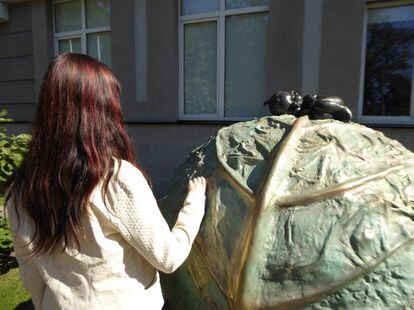 Milana, embarazada para terceros, en la clínica Ilaya en Kiev, junto a una escultura que alude a una leyenda local de que los niños surgen de un repollo.