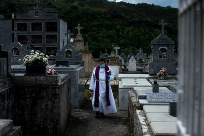 Un sacerdote atraviesa un camposanto durante un entierro en la crisis sanitaria por la Covid-19.