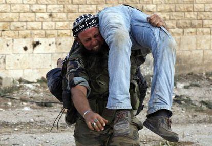 Un miliciano del Ejército Libre de Siria traslada el cadáver de un compañero, el sábado.