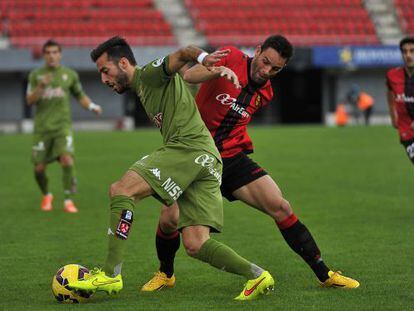 Dos jugadores luchan por el bal&oacute;n durante el Mallorca-Sporting