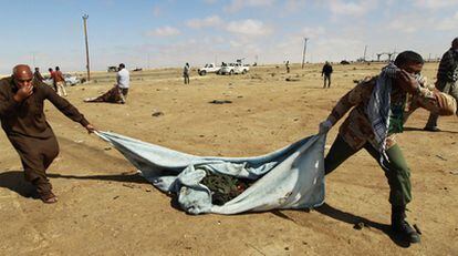 Los rebeldes retiran cadáveres de fallecidos hace días en un ataque de la OTAN en Ajdabiya.