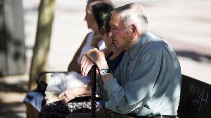 Un hombre mayor, junto a otras ancianas, en un banco en la calle Alcalá (Madrid).