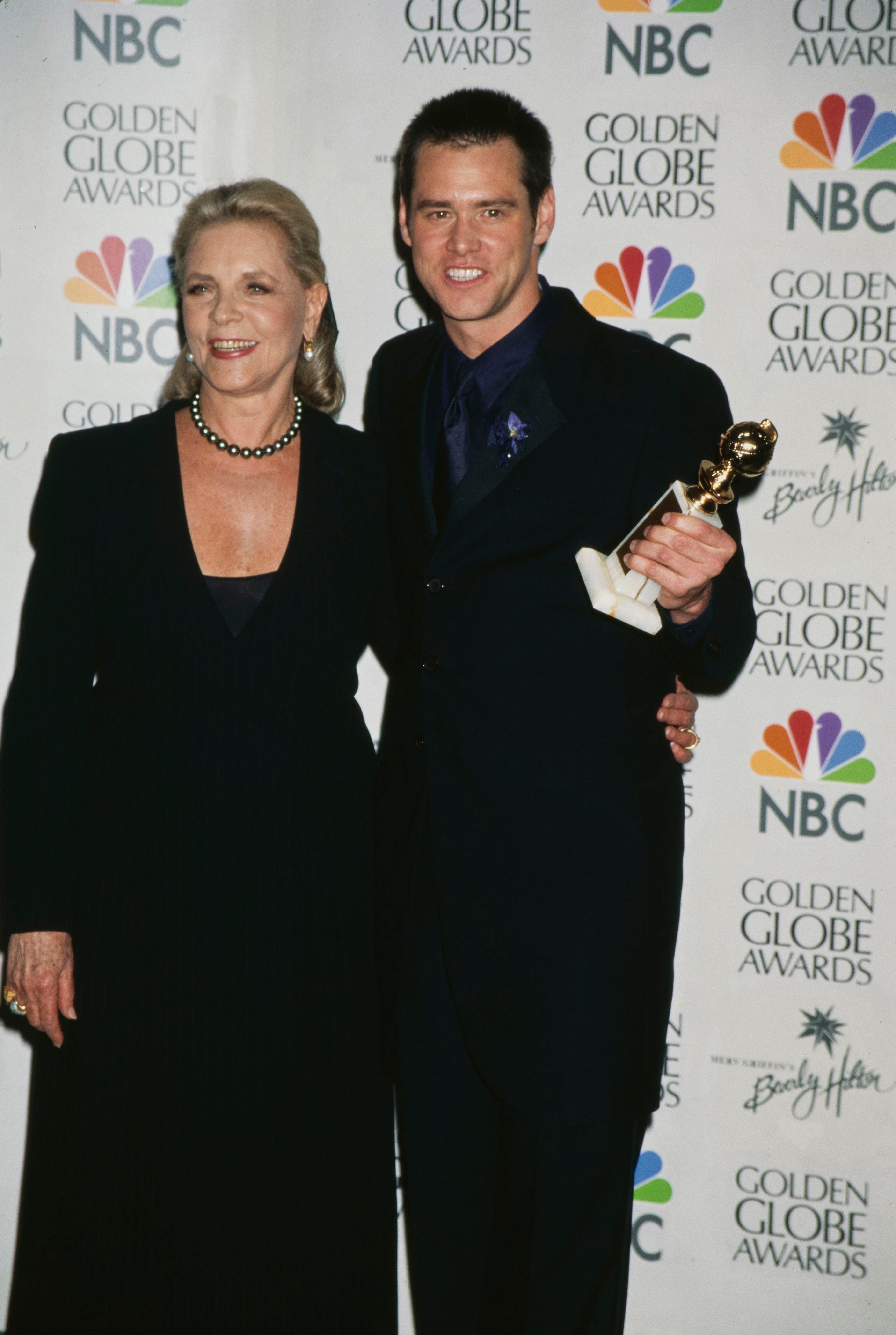 Lauren Bacall y Jim Carrey, este sujetando en su mano el Globo de Oro que ganó por 'El show de Truman'. 