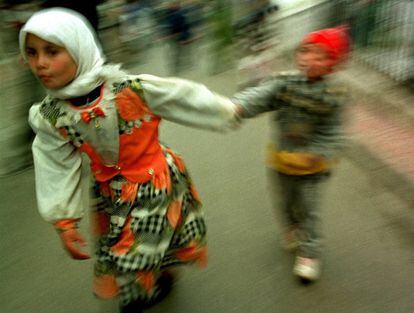 Una niña vestida con traje típico junto a su hermano en el zoco de Tánger (Marruecos)