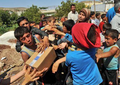 Niños sirios pelean por las cajas de un camión capturado por los rebeldes sirios cerca del puente fronterizo de Bab al-Hawa.