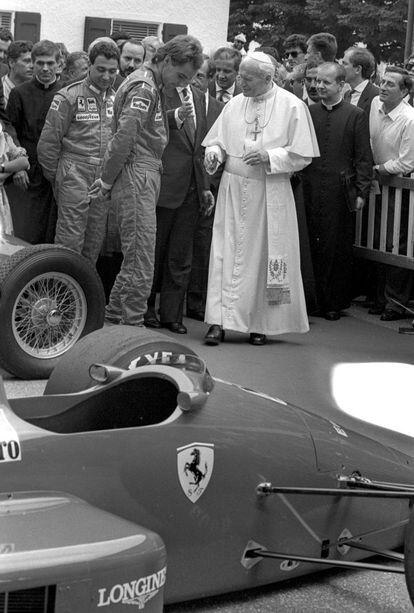 El Papa Juan Pablo II saluda a los pilotos de Ferrari Michele Alboreto, izquierda, y Gerhard Berger, derecha, ante un Ferrari en 1988.