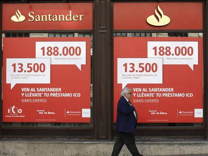 Un hombre camina frente a un banco Santander