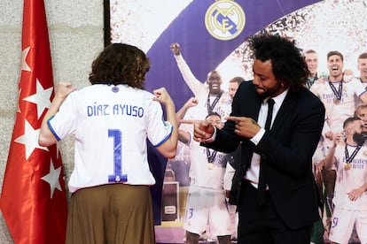 La presidenta de la Comunidad de Madrid, Isabel Díaz Ayuso, tras recibir una camiseta con su nombre de manos del capitán del Real Madrid, Marcelo Vieira.