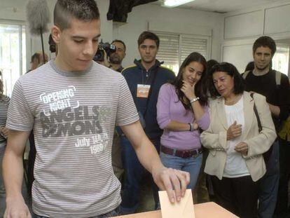 La candidata de IU a la Comunidad de Madrid, Inés Sabanés, observa votar por pimera vez a su hijo Javier.