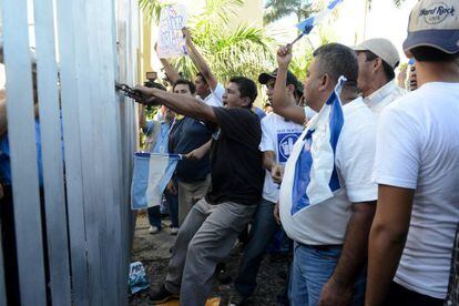 Un grupo de hombres protesta en la puerta de la Asamblea.