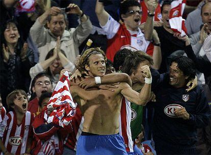 Agüero abraza a Forlán tras el segundo gol del uruguayo, el que le ha dado la victoria al Atlético.