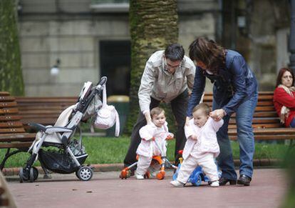 Dos padres atendiendo a sus hijos en un parque de Bilbao