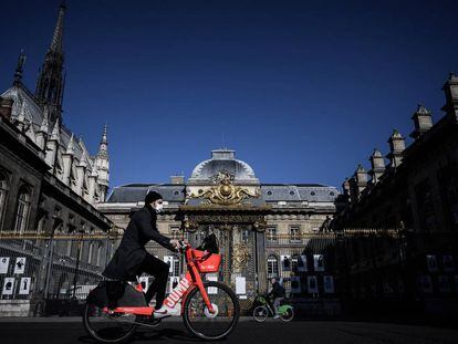 Un hombre pasa en bicicleta por el Palais de Justice, en la Île de la Cité, París, el pasado mayo.