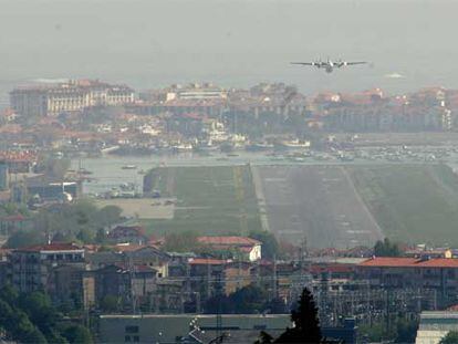 Un avión se dispone a tomar tierra en el aeropuerto de Hondarribia, con Hendaya al fondo.