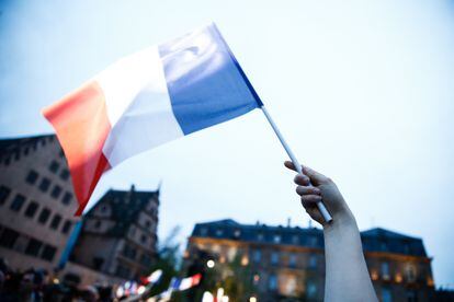 Un manifestante ondea una bandera francesa durante un acto electoral de la campaña presidencial.