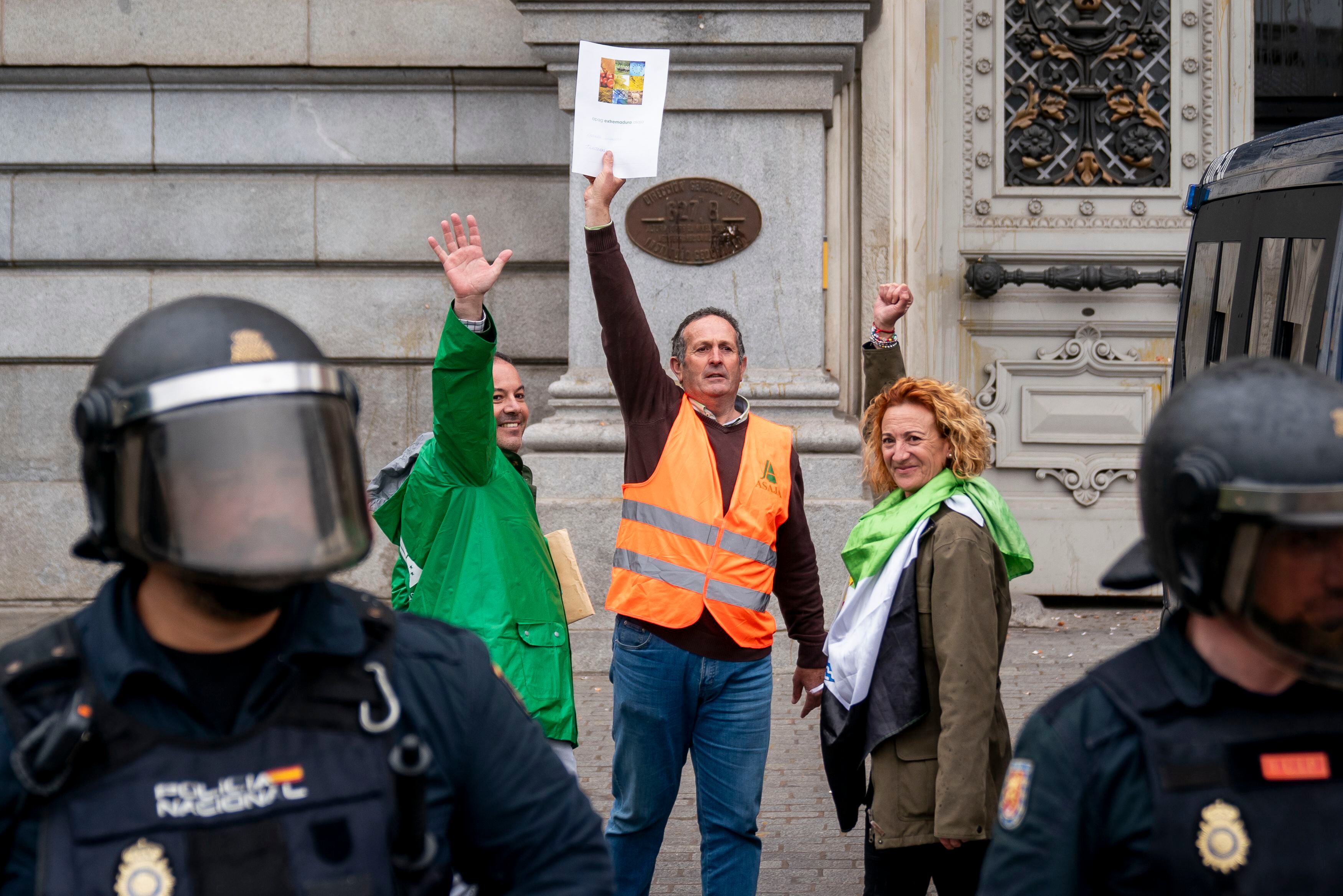 Representantes de Asaja sujetan unos folios con sus reivindicaciones frente a la sede del Ministerio de Agricultura, este jueves en Madrid.
