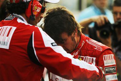 Un técnico de Ferrari consuela a Alonso tras la carrera de Abu Dabi.