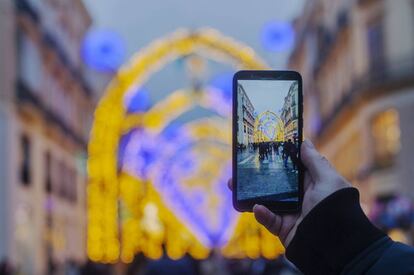 Un turista realiza una foto con su móvil en la calle Larios de Málaga el pasado mes de diciembre.