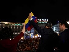 Venezuela's opposition leader Juan Guaido, who many nations have recognised as the country's rightful interim ruler, holds the Venezuelan national flag with Madrid's regional president Isabel Diaz Ayuso, as he greets supporters from the balcony of the headquarters of Madrid's regional government in Madrid, Spain, January 25, 2020. REUTERS/Susana Vera