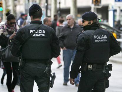 Dos antidisturbios de los Mossos con el chaleco y el NOP actual visible en la espalda.