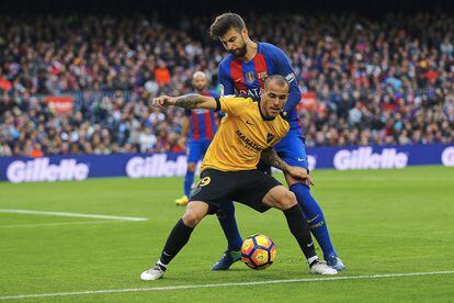 El defensa del Barcelona Gerard Piqué (en segon pla) disputa una pilota davant el davanter Sandro Ramírez (en primer plànol), del Màlaga.