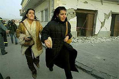 Dos ciudadanas de San Giuliano dei Puglia huyen tras el nuevo temblor de tierra.