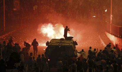 Entrada la noche, los enfrentamientos continuaban en El Cairo. En la imagen, un polic&iacute;a antidisturbios dispara a los manifestantes desde un veh&iacute;culo blindado. 