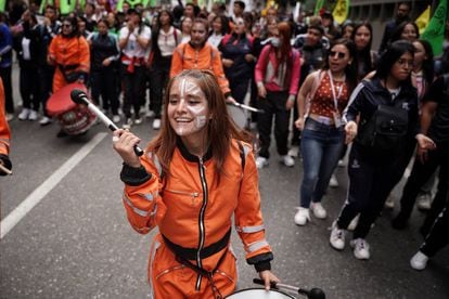 Una joven, integrante de un grupo de batucada, toca el tambor durante la marcha de este miércoles en Bogotá.