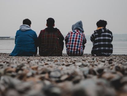Cuatro adolescentes miran al horizonte.