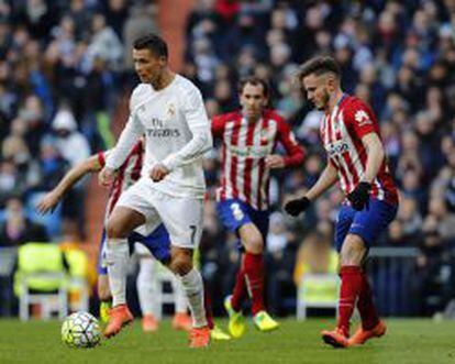 Cristiano Ronaldo, jugador del Real Madrid, es perseguido por el centrocampista del Atlético de Madrid, Saúl