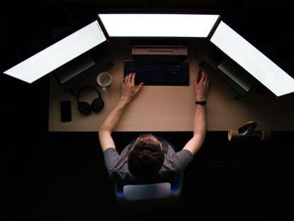Un experto en seguridad informática trabaja frente a múltiples pantallas de ordenador.