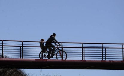 Un padre pasea en bici con su hijo en Vitoria.