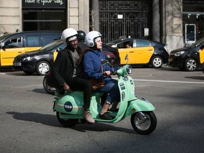 Usuarios de motos de alquiler por minutos de la empresa YeGo circula por Barcelona.