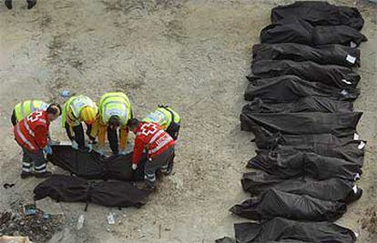 Empleados de los servicios de Urgencia de Madrid alinean los cadáveres de las víctimas en la estación de Atocha.