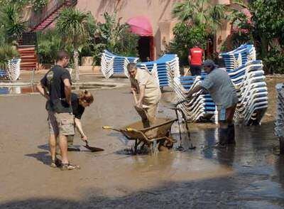 Empleados de un hotel de Almuñécar limpiaban ayer la piscina tras la riada del pasado viernes.