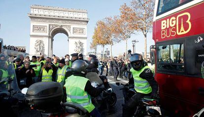 Manifestantes contra la subida de los combustibles bloquean el paso de un autobús turístico, este sábado en París.