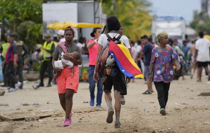 Un migrante lleva una bandera venezolana en Necoclí, el 13 de octubre.