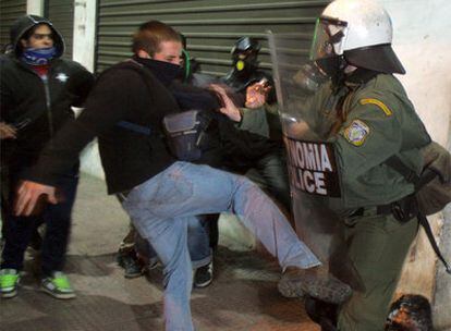 Un joven se enfrenta a un agente de la policía antidisturbios durante una nueva protesta por la muerte de un adolescente en Atenas