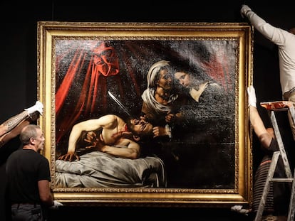 Unos trabajadores cuelgan un posible 'caravaggio',  'Judith y Holorfenes', días antes de una subasta en Francia, en verano de 2019.