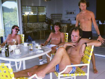 Mark Knopfler, en primer término, posa en la isla de Montserrat junto al resto de la formación de Dire Straits en 1985, el año en que fue lanzado el tema 'Money for nothing'. El otro miembro del grupo, John Illsey, no quiso salir en la foto: solo se intuyen las piernas a la izquierda de la imagen. En vídeo, actuación de Mark Knopfler en Milán en 2019 en la que cambia el "faggot" de la letra por "mother", en alución a "motherfucker".